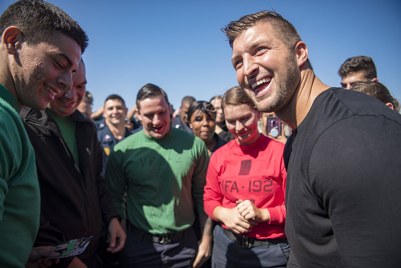 Tim Tebow interacts with Sailors on the flight deck of Nimitz-class aircraft carrier USS Carl Vinson (CVN 70) during a visit to the ship.