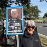 A protester holds a sign denigrating President Donald Trump