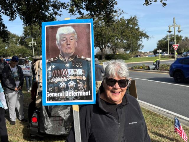 A protester holds a sign denigrating President Donald Trump