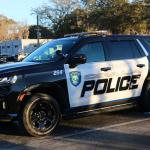 A black and white police car sits in a parking lot with silver and black text on the side reading, "Ocala Police," with a City of Ocala police logo next to it.
