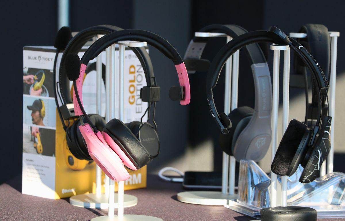 Headphones are displayed on stands while closed boxes with more headphones stand in the background.