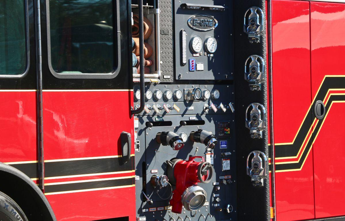 A red, black and yellow first responder truck features a panel with multiple mechanical components.
