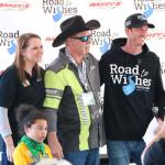 A group of people stand together for a photo in front of a back drop that reads, "Road to Wishes Truck Show" and "Raney's."