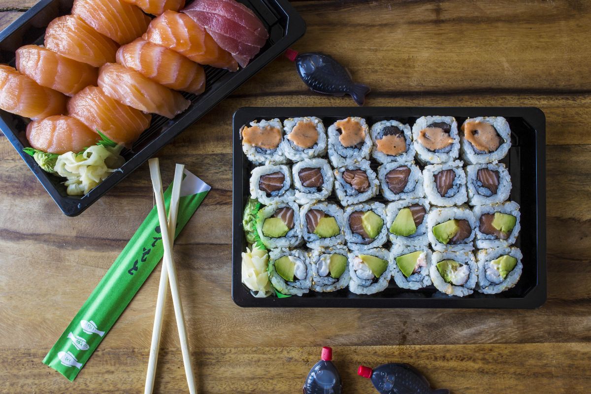 A plate of sushi with chopsticks on a wooden table.
