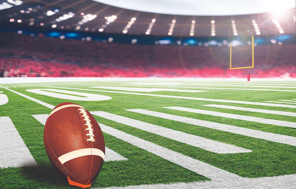 football on field in lighted stadium