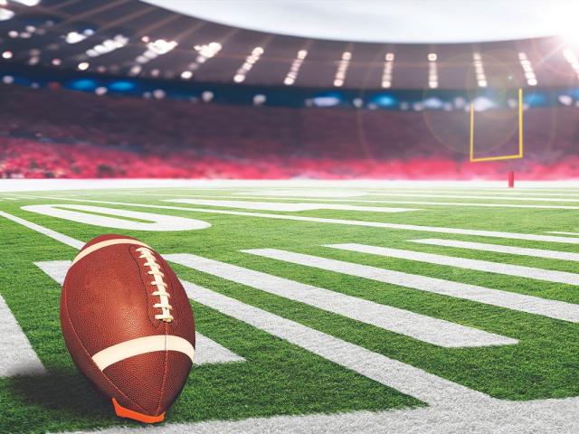 football on field in lighted stadium