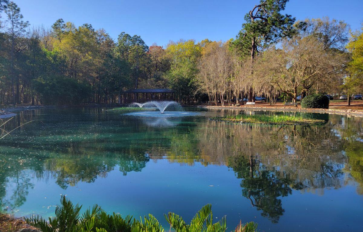 A man-made lake with a foundation and a gazebo in the background.
