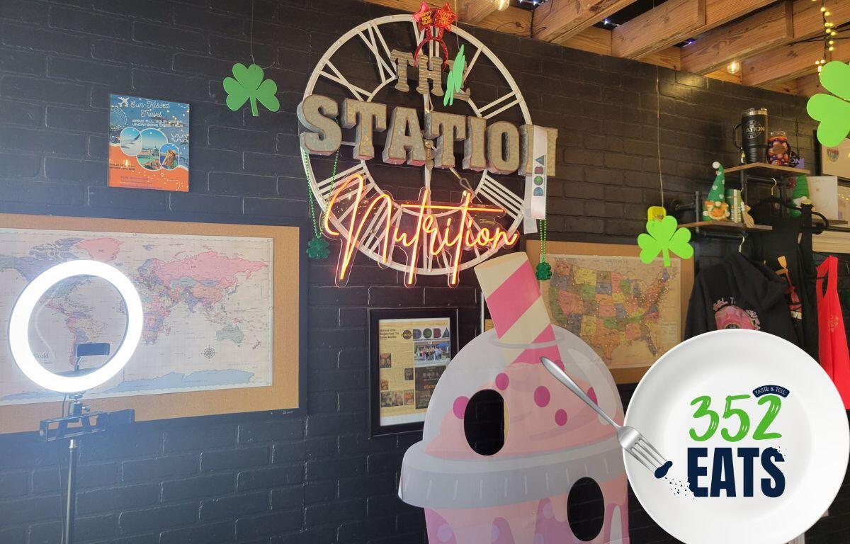 A sign that says, "The Station Nutrition" against a black wall.