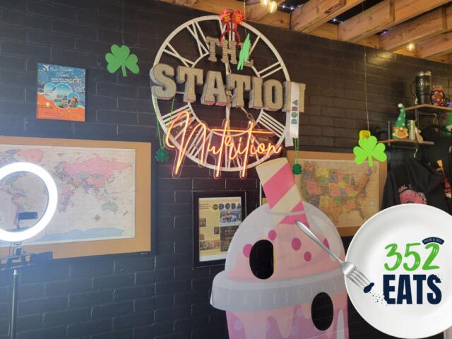 A sign that says, "The Station Nutrition" against a black wall.