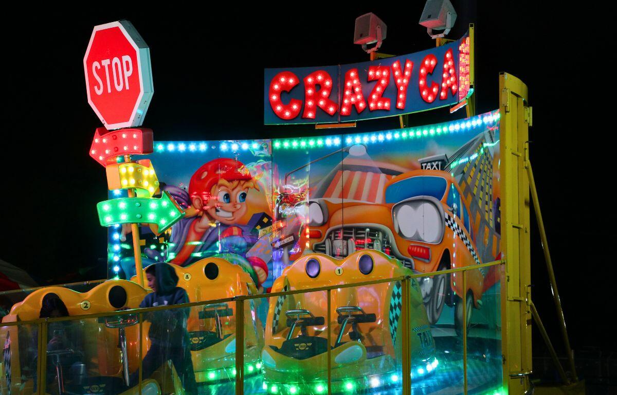 A small kids' ride features small two-person seats, decorated like taxis.