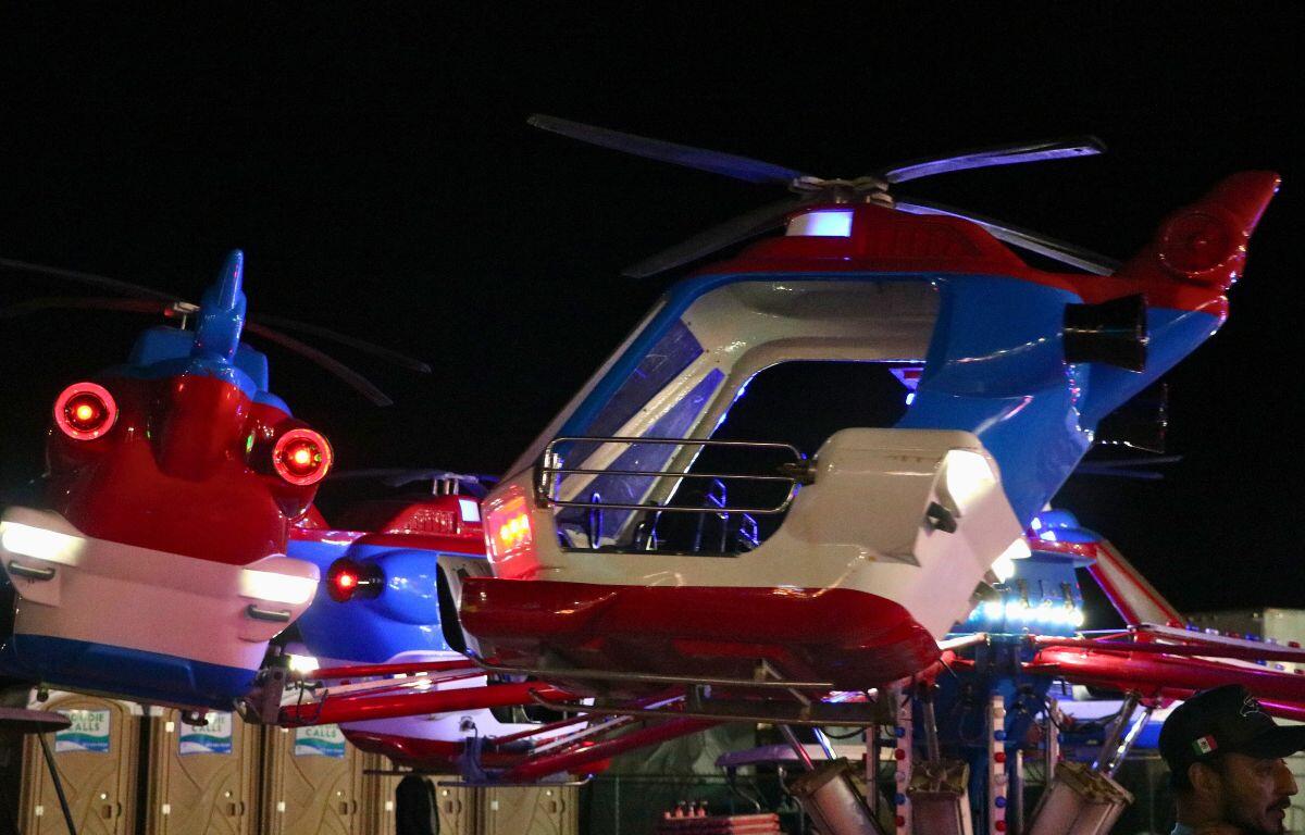 A small kids' ride with seats in the shape of helicopters goes around in a circle.