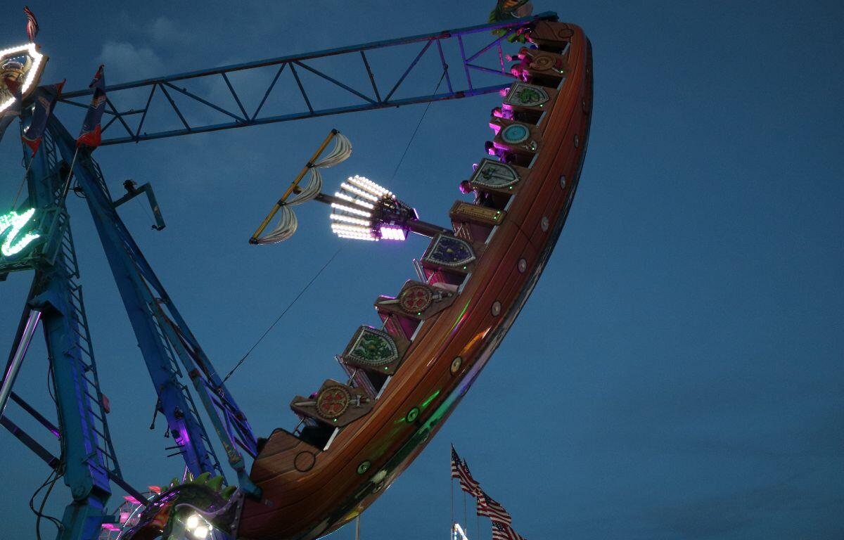 A pirate ship ride swings guests high in the air from large, metal supports.