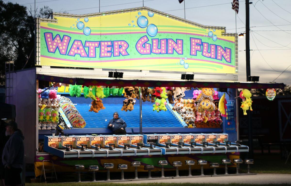 A game stand features a water gun race where guests can compete for prizes.