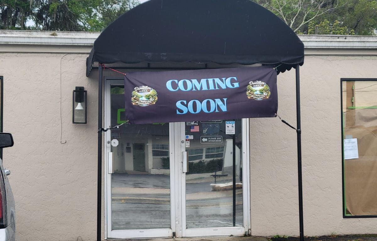 A beige storefront with a sign that reads, "Coming Soon."