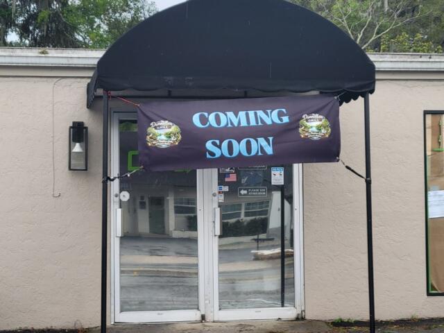 A beige storefront with a sign that reads, "Coming Soon."