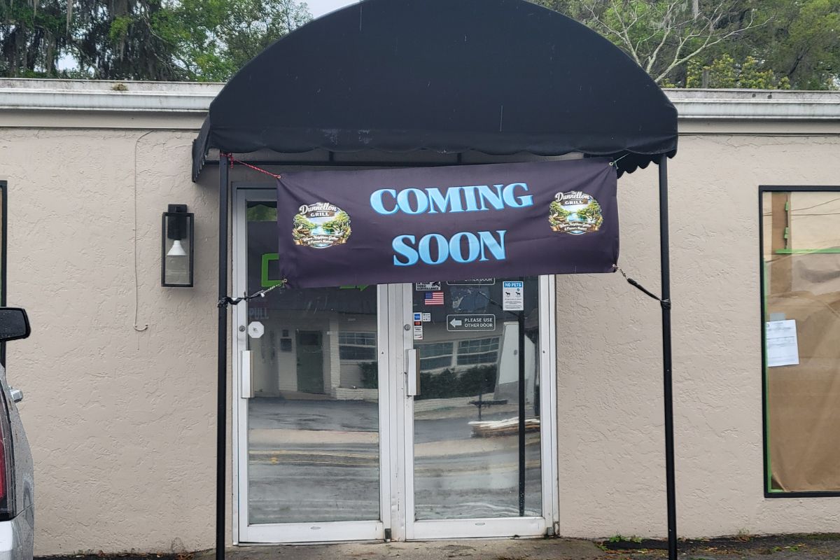 A beige storefront with a sign that reads, "Coming Soon."