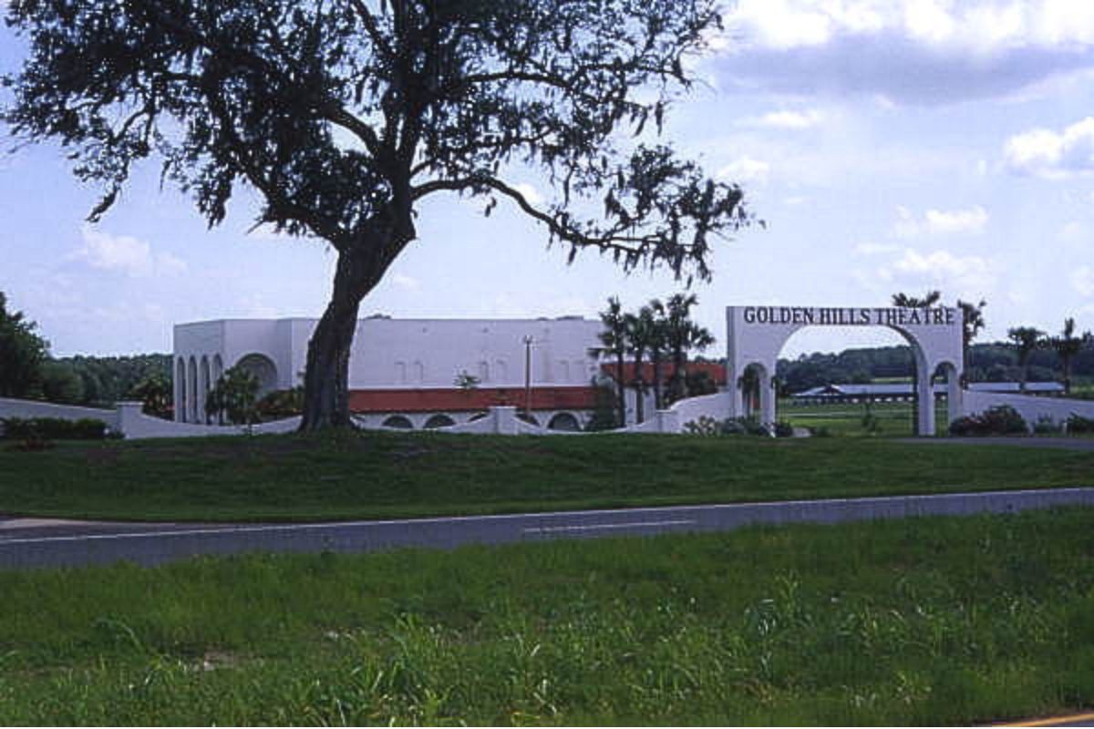 A colored photo of a white building labeled "Golden Hills Theatre" behind a tree.