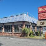 A colored photo of a restaurant building with a sign that reads, "Wolfy's."