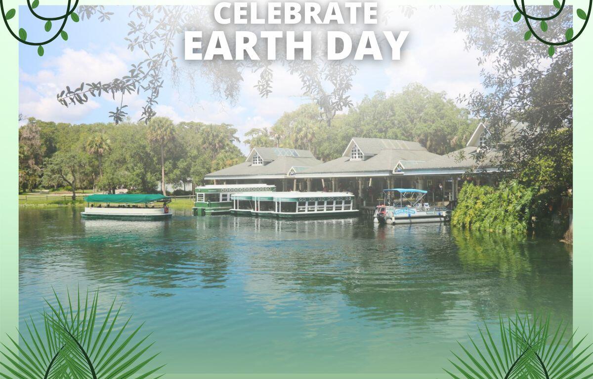 A view of a loading dock with boats floating on clear water in a wooded area sits on top of a green background. In the foreground is white text that reads, "Celebrate Earth Day." Graphics of vines and palm leaves.