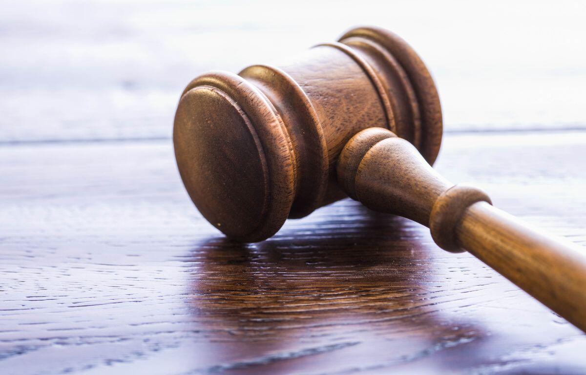 A colored image of a gavel on a wooden table.