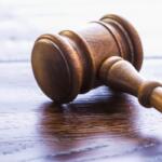 A colored image of a gavel on a wooden table.