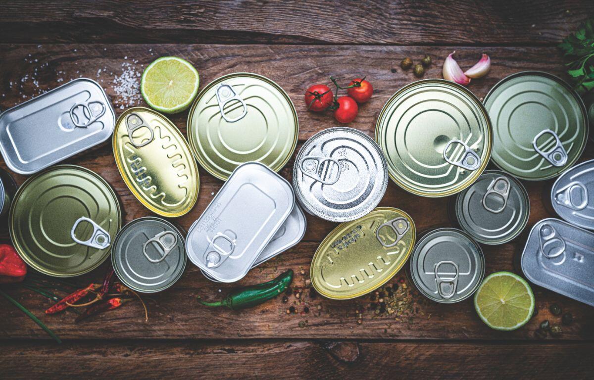 A colored image of canned goods top-down against a wooden background.