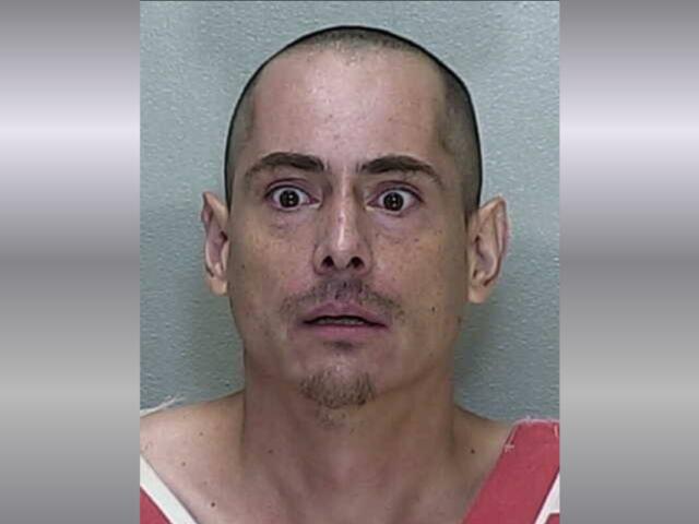 A mugshot of a man in a orange and white striped jumpsuit.