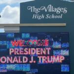 A digital sign with different colors, with a static sign over the digital sign.