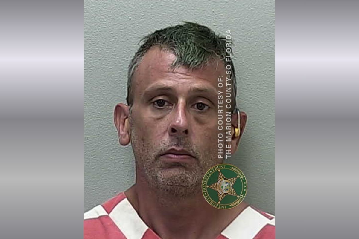 A mugshot of a man in an orange and white striped jumpsuit.