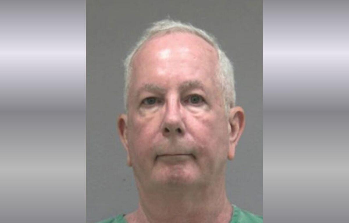 A mugshot of an older man in a green jumpsuit.