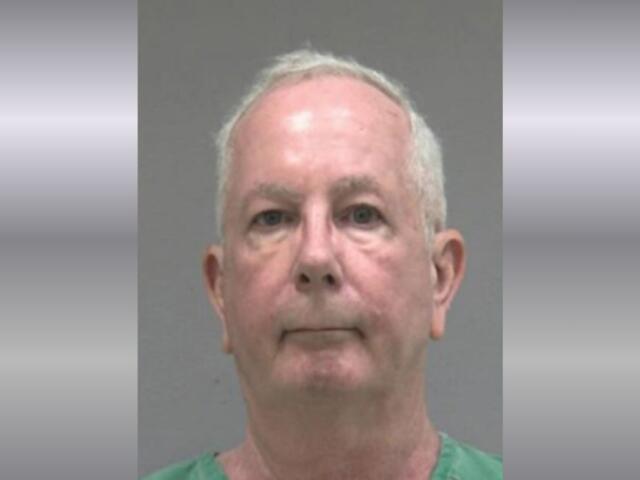 A mugshot of an older man in a green jumpsuit.