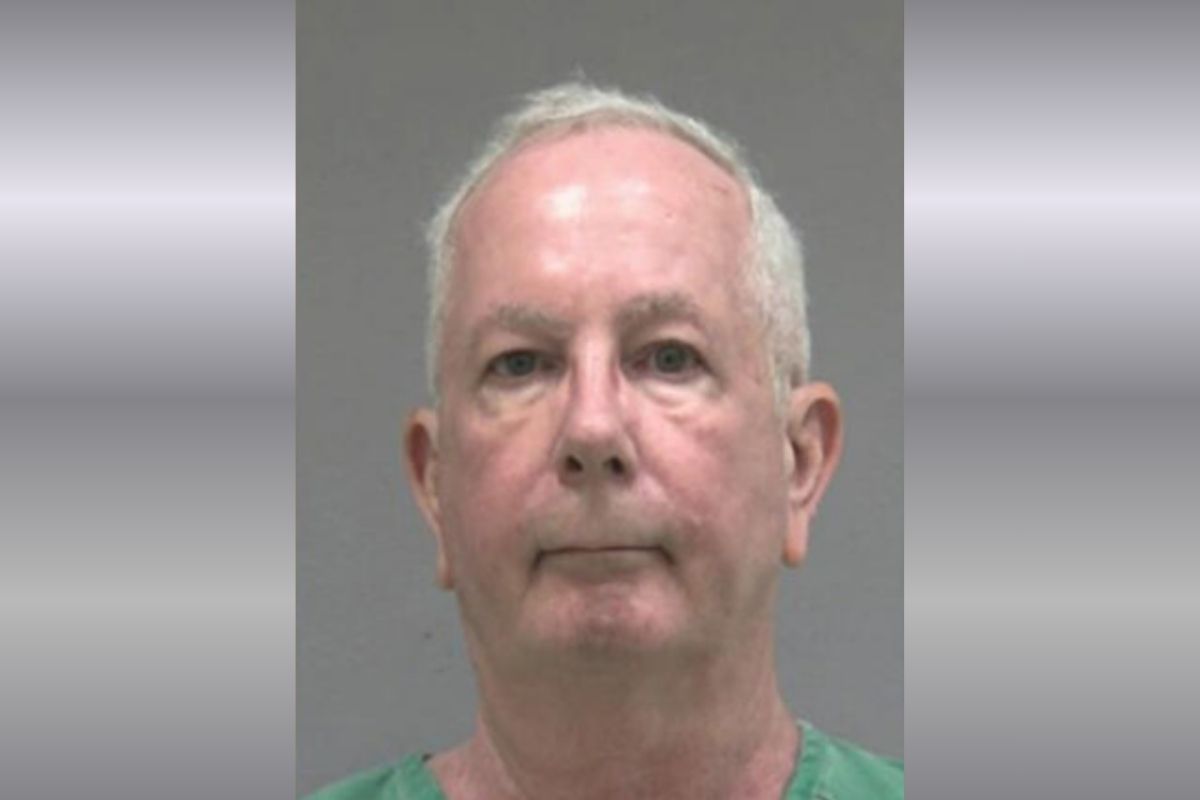 A mugshot of an older man in a green jumpsuit.