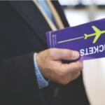 A colored image of a man in a suit holding a blue airline ticket.