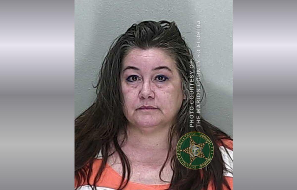 Mugshot of a middle-aged woman with wet brown hair in an orange jail jumpsuit, facing the camera; Marion County Sheriff's Office watermark visible on the right.