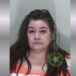 Mugshot of a middle-aged woman with wet brown hair in an orange jail jumpsuit, facing the camera; Marion County Sheriff's Office watermark visible on the right.