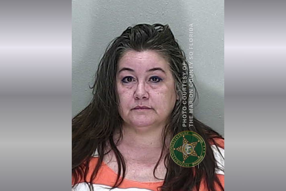 Mugshot of a middle-aged woman with wet brown hair in an orange jail jumpsuit, facing the camera; Marion County Sheriff's Office watermark visible on the right.