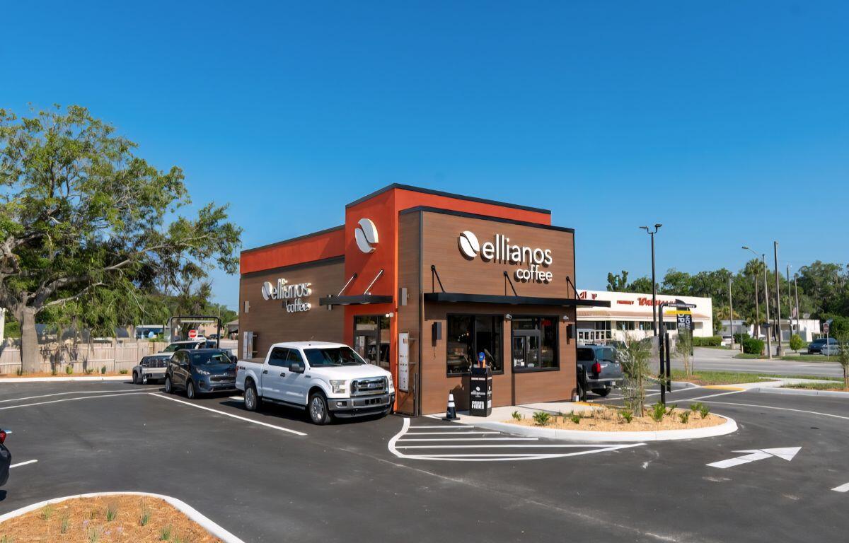 A colored image of a brown and orange coffee shop with an occupied drive-thru.
