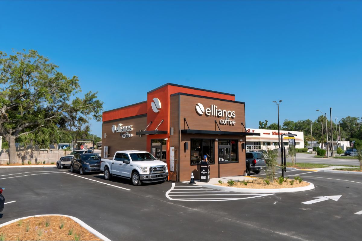 A colored image of a brown and orange coffee shop with an occupied drive-thru.