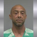 Mugshot of a bald man wearing a green jail uniform, facing the camera with a neutral expression.