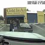 Dashcam footage of a man being arrested by police outside of a black Ford Mustang.