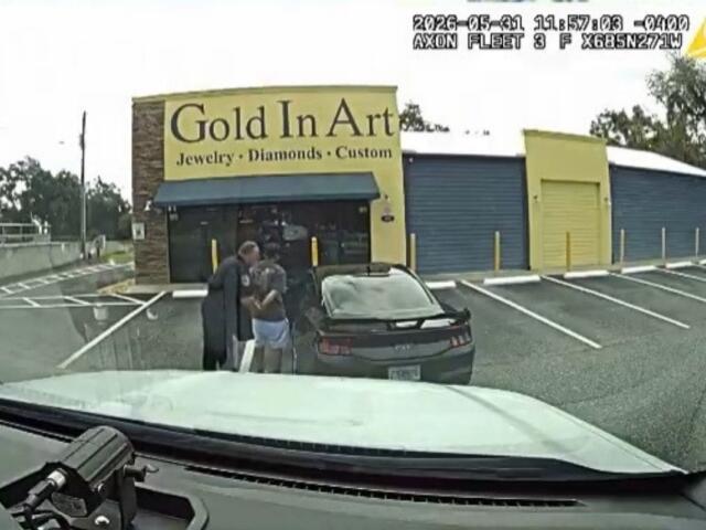 Dashcam footage of a man being arrested by police outside of a black Ford Mustang.