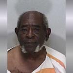 An older African American man in an orange and white striped jumpsuit.