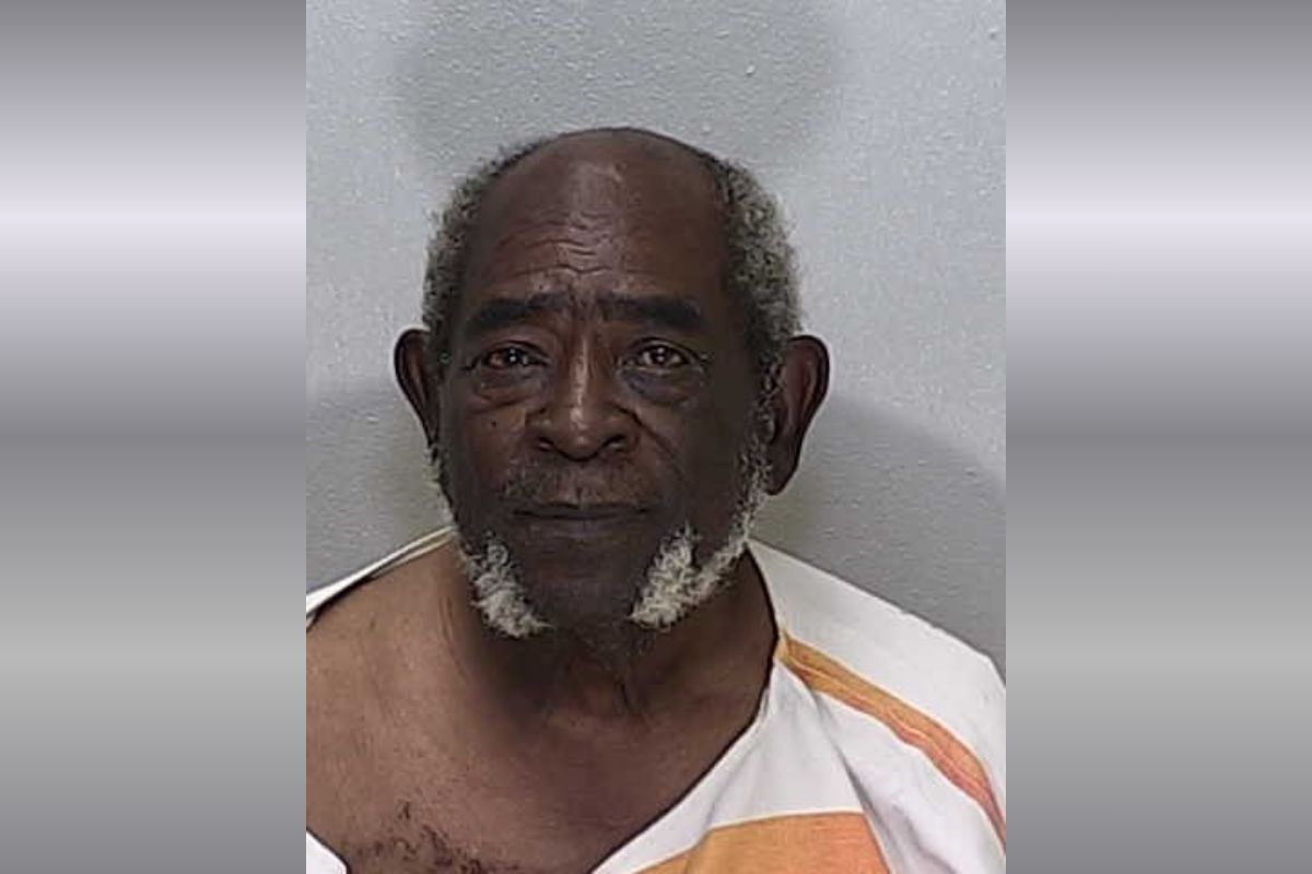 An older African American man in an orange and white striped jumpsuit.