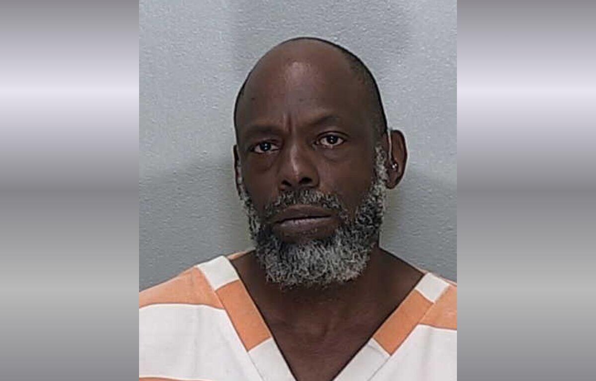 A mugshot of an African American man with a gray beard.