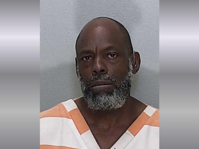 A mugshot of an African American man with a gray beard.