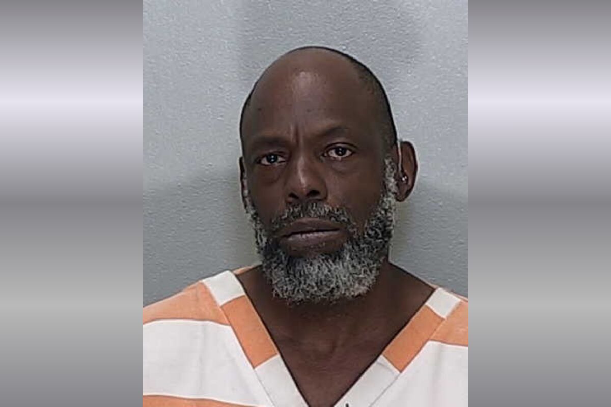 A mugshot of an African American man with a gray beard.