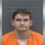 A white man with short brown hair in an orange jumpsuit.