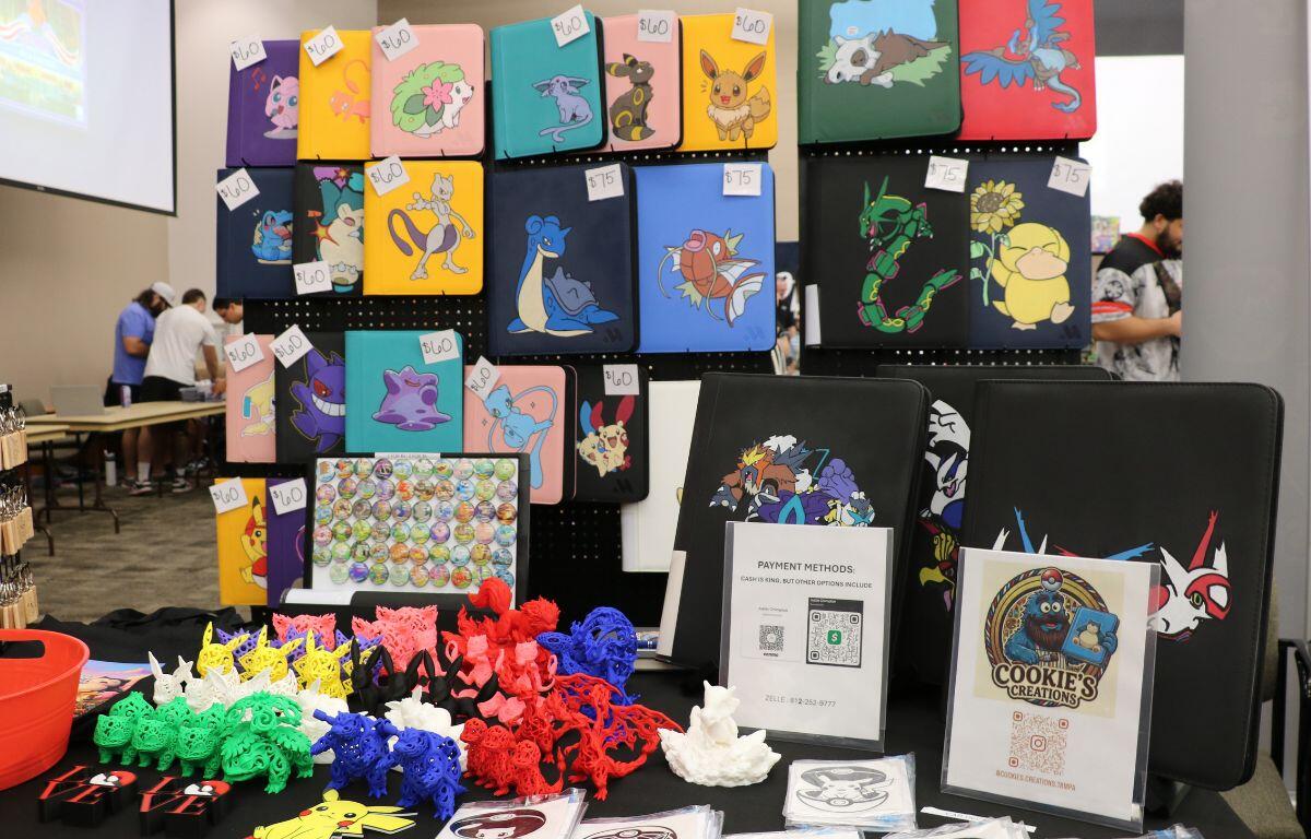 Colorful display of character-themed cases and merchandise at a convention booth for sale.