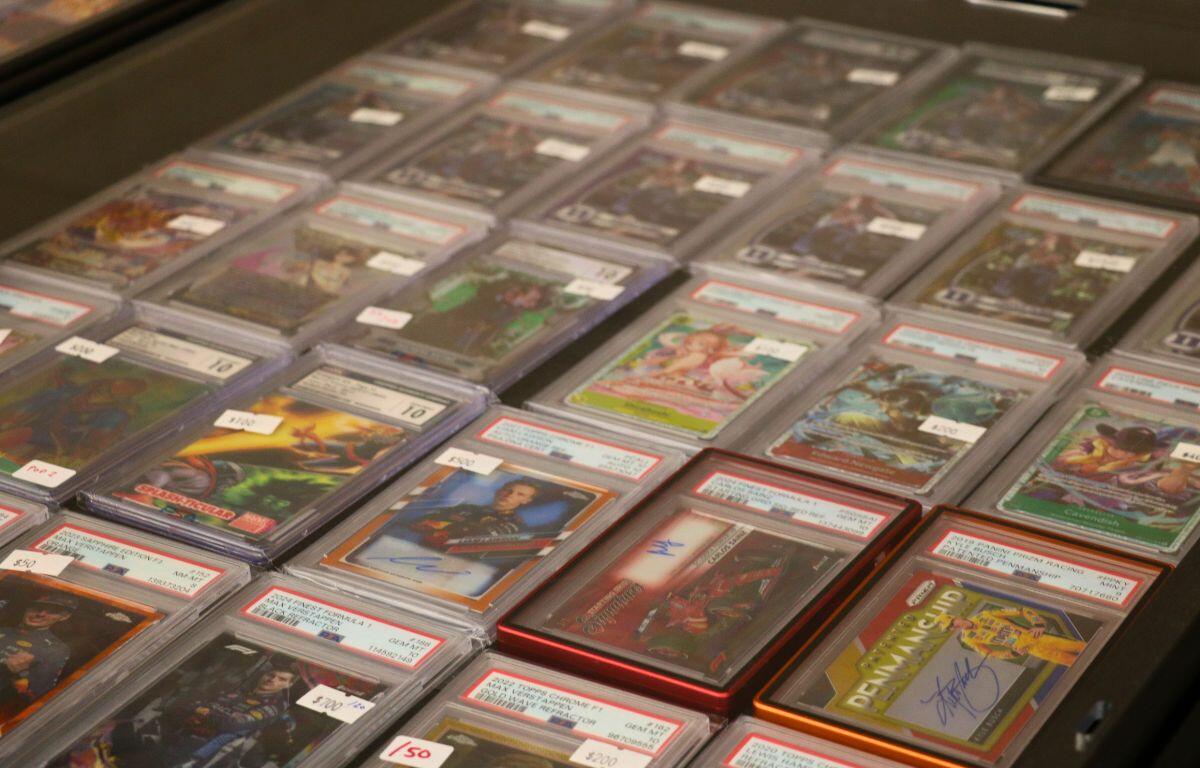 Rows of priced sports trading cards in clear plastic cases laid out on a display table, viewed from above.