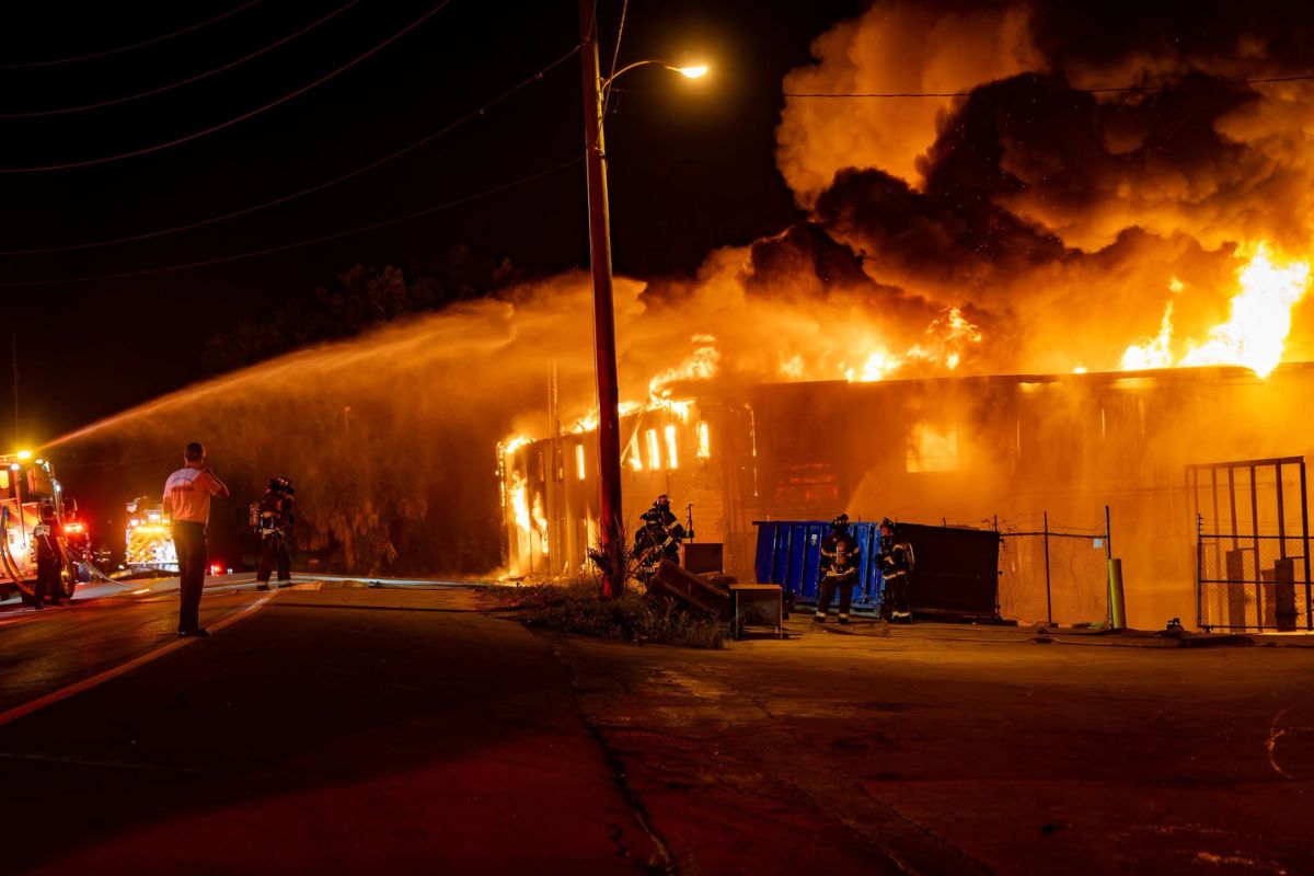 Firefighters work to extinguish the flames of a large commercial building.